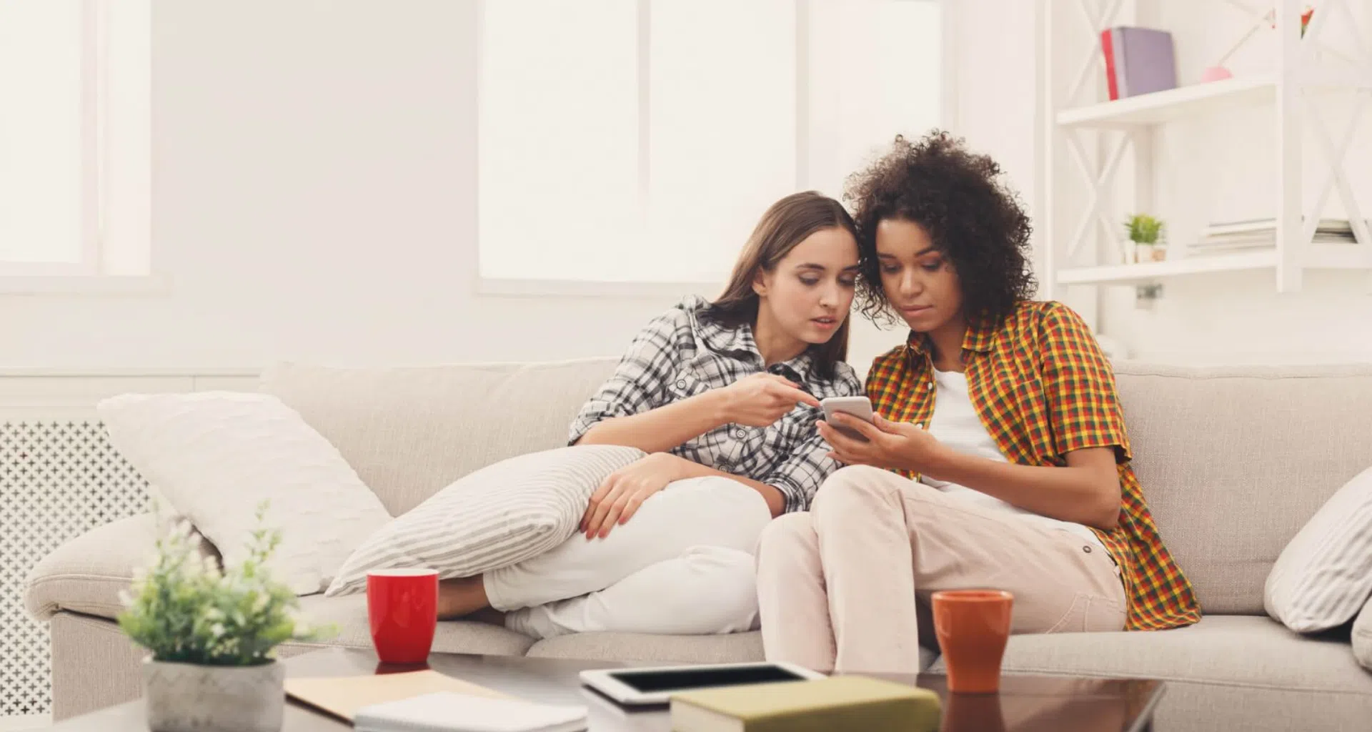 Mujeres que buscan aplicaciones de televisión para teléfonos inteligentes