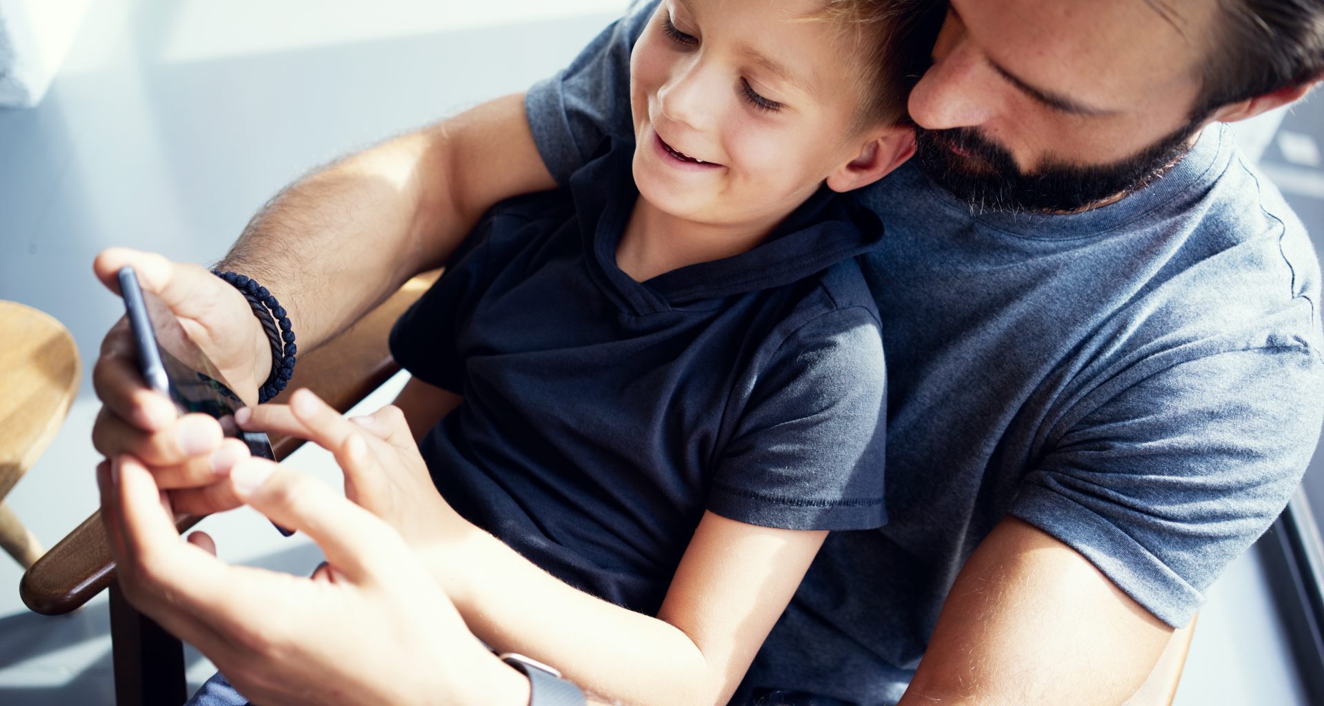 Pai e filho jogando smartphone
