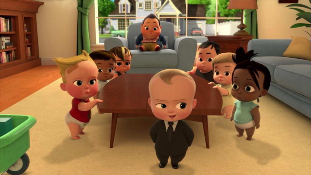 Vários bebês reunidos na sala de uma casa. Todos olham para o bebê protagonista.