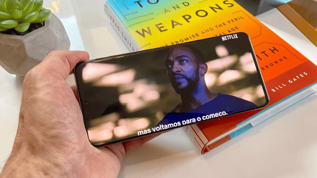Recensione: samsung galaxy s20 ultra offre fotocamera e display spettacolari La mano tiene la galassia s20 ultra con i contenuti netflix sullo schermo