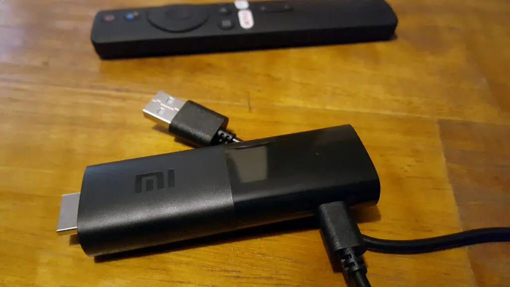 Review: roku express e mi tv stick trazem o melhor do streaming para sua tv Mi tv stick sobre mesa de madeira