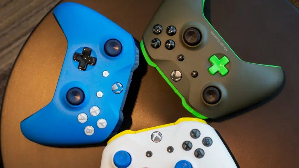 Utvecklingen av Xbox: Hur Microsoft-konsolen blev en jätte i spelbranschen Tre kontroller från xbox ones version, i blå, vita och gröna färger.