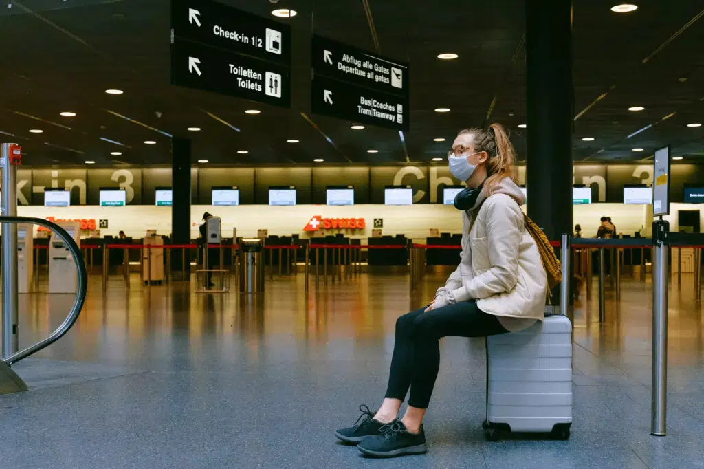 Rappi travel è la scommessa di Rappi per la ripresa del settore turistico Donna seduta in aeroporto con una maschera