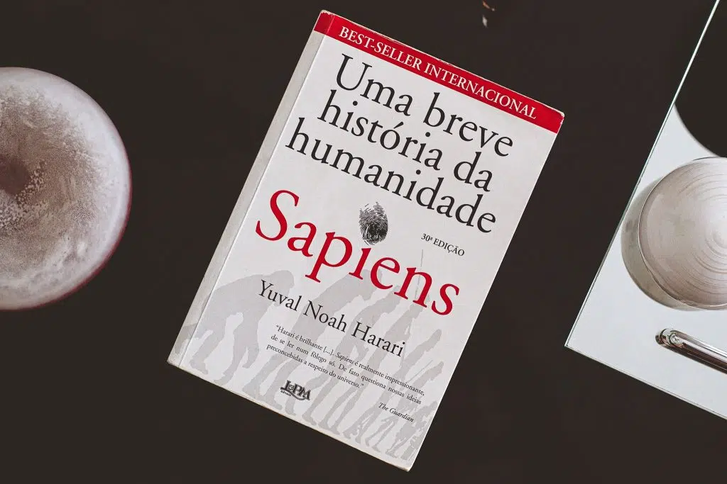 Os 30 melhores livros sobre ciência Capa do livro sapiens em cima de uma mesa preta