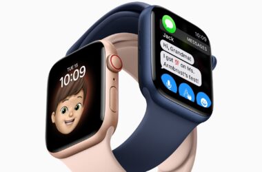 Dois modelos do apple watch series 6, um rosa dourado com pulseira sport rosa e um azul com pulseira sport azul entrelaçados. O rosa exibe o mostrador memoji, o azul uma tela de mensagens