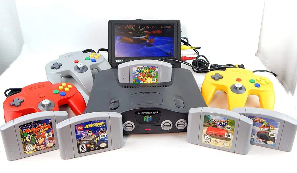 A história da nintendo: de baralhos aos consoles caseiros O nintendo 64 com diversas fitas e um periférico de tv acoplado a ele.