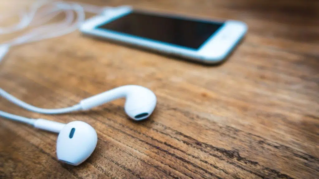 14 apps para baixar música no celular de graça Fone de ouvido em cima de um celular