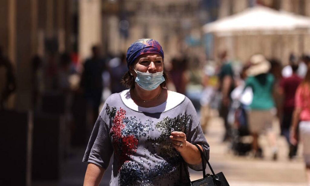 Mulher em israel realizando uso de máscara de forma incorreta