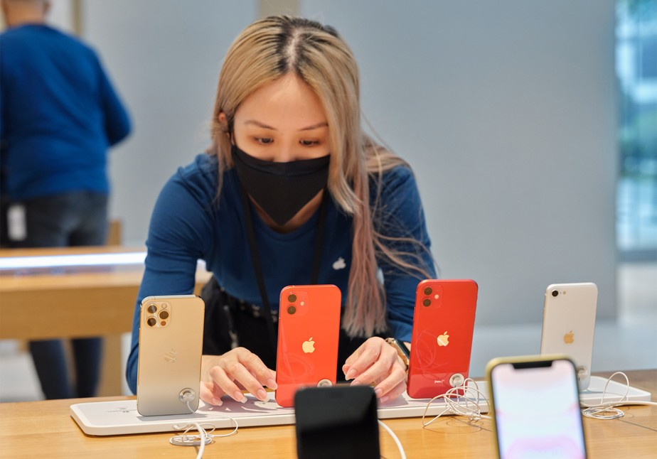 Mulher observando um iphone em loja da apple