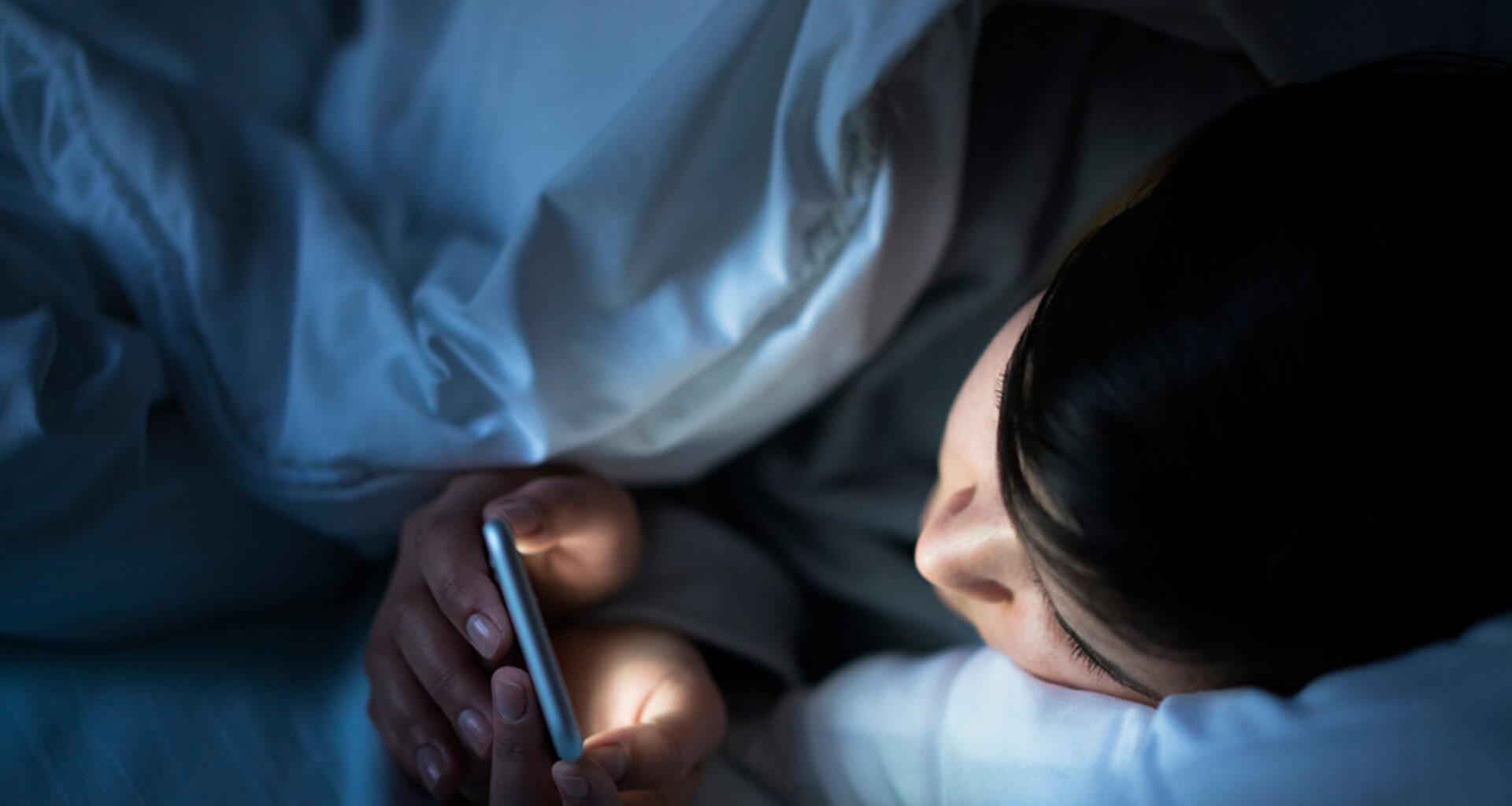 Mulher usando apps de monitoramento na cama