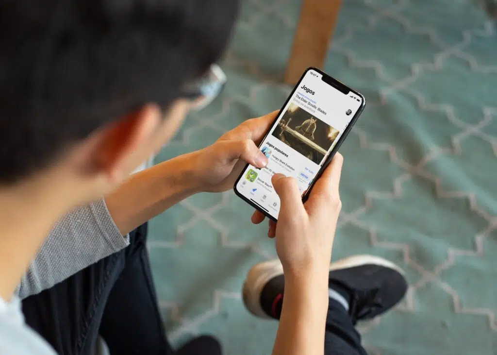 Gastos em apps de smartphones cresce 25% em 2021 Homem usando iphone