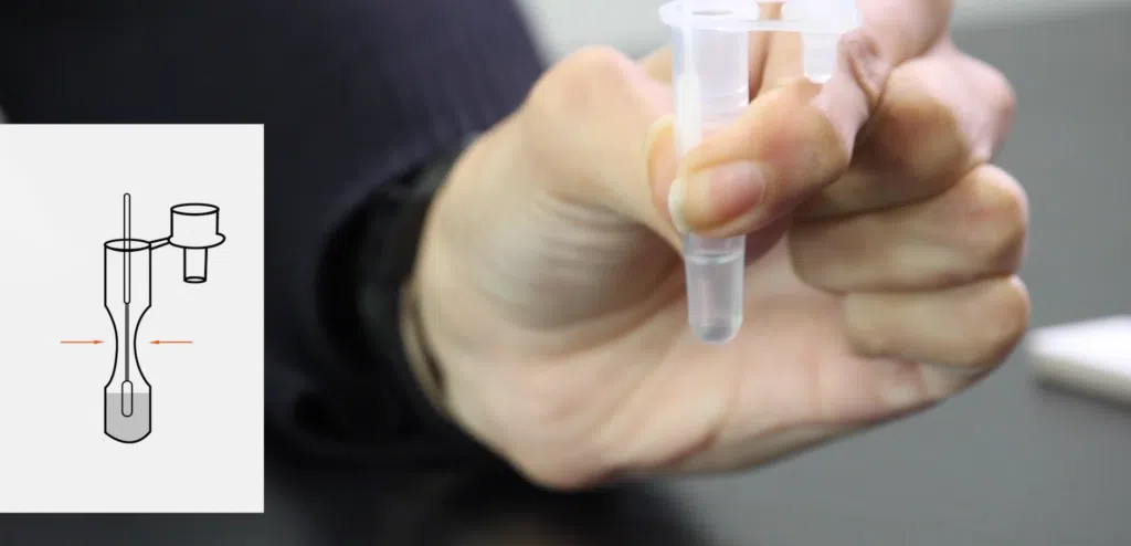 Como funciona e onde comprar autoteste de covid-19 Mulher segurando tubo com reagente do autoteste de covid-19