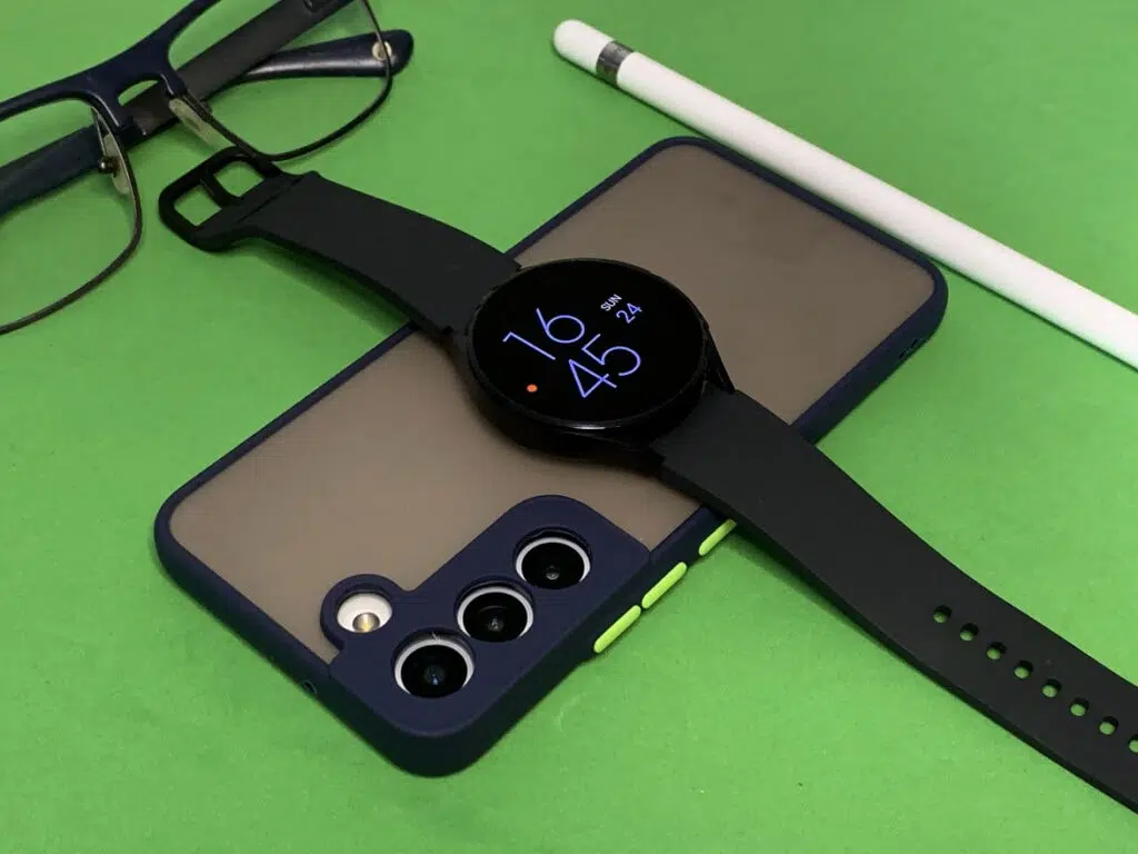 Review galaxy s22: o que tem de novo? Galaxy s22, óculos, apple pencil, galaxy watch 4 em cima de superfície verde