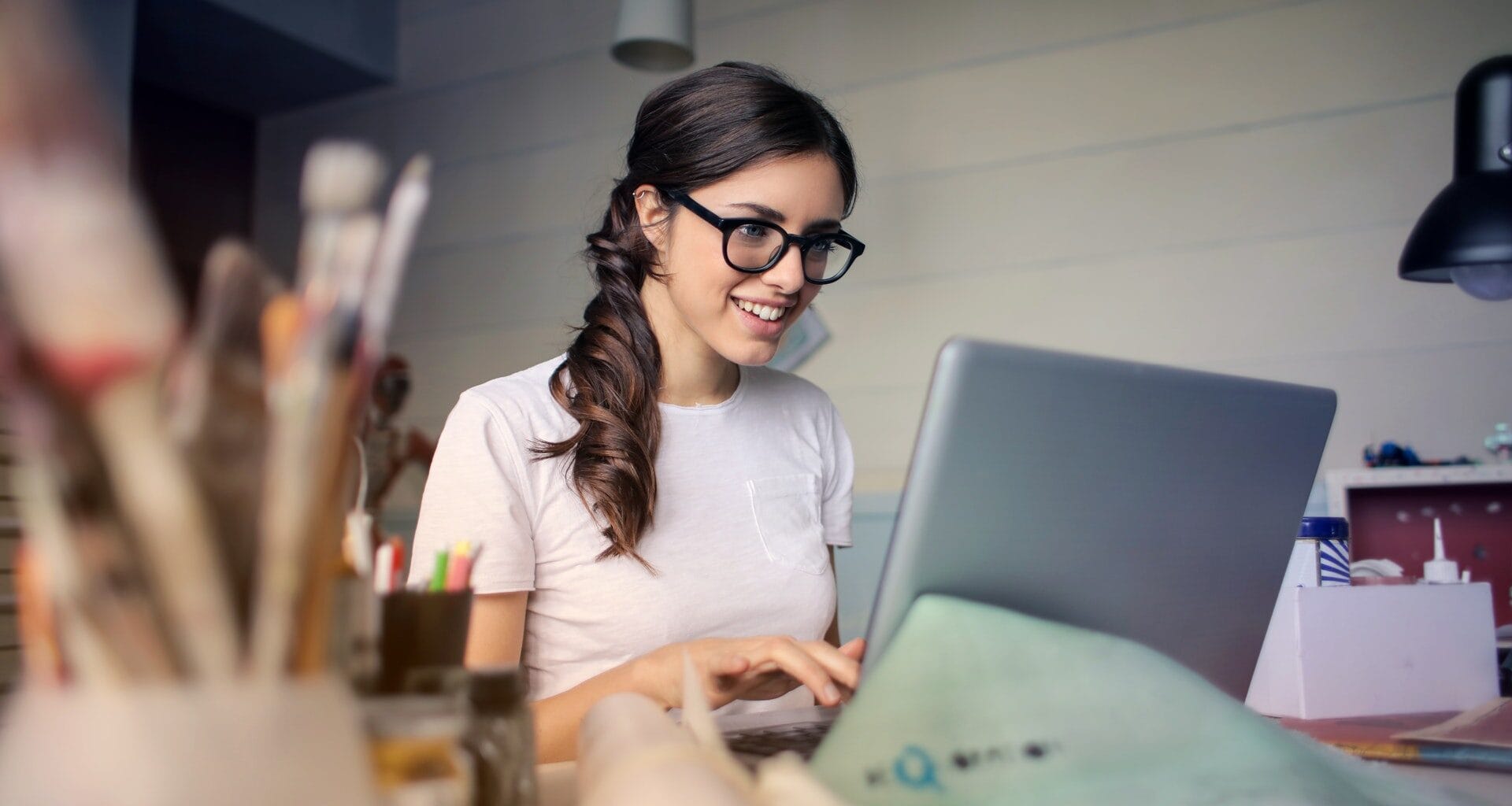 A imagem mostra uma mulher usando um notebook mais rápido e feliz com isso