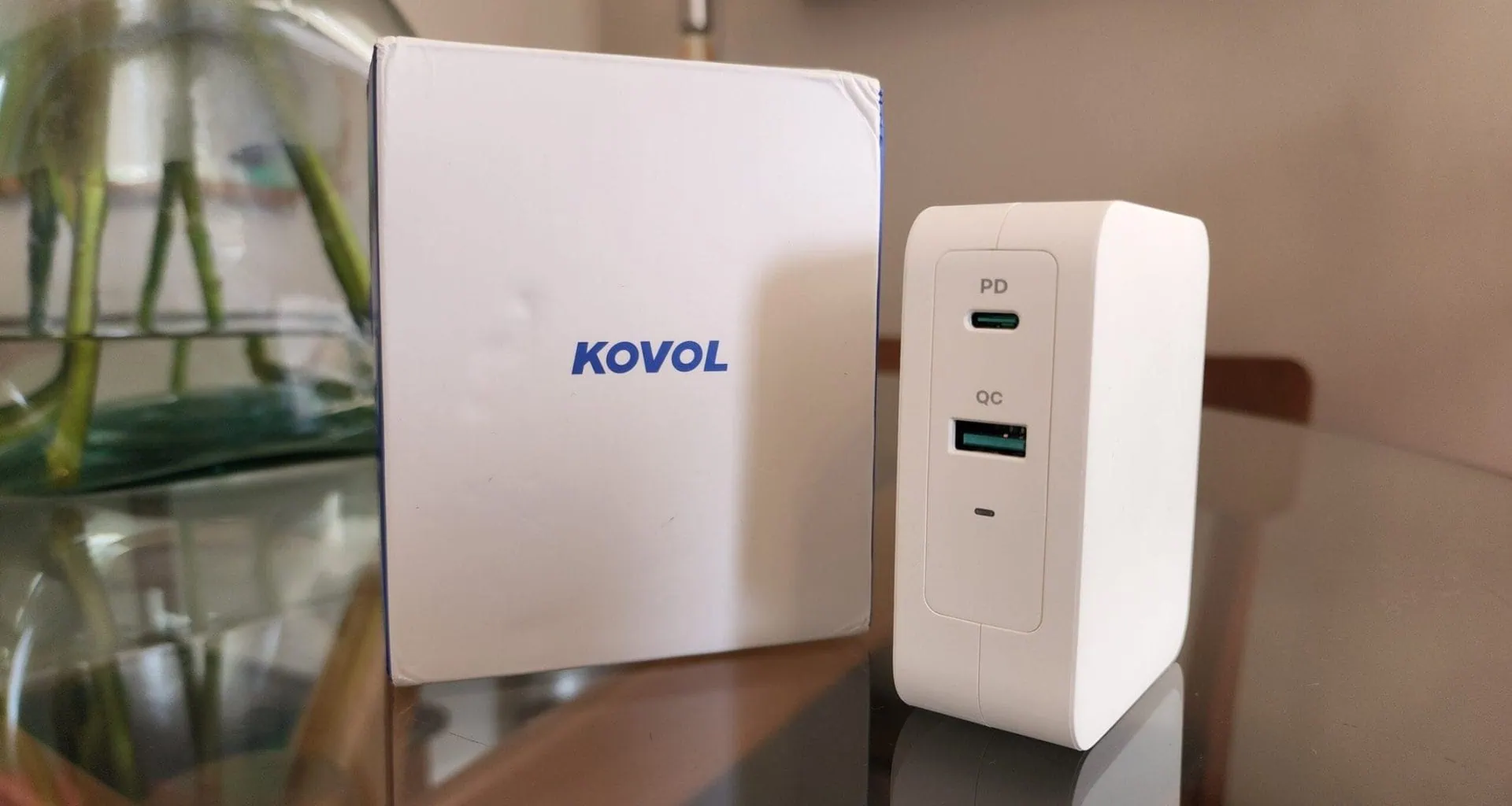 ガラス テーブルのボックスの横にある 140 w kovol 充電器