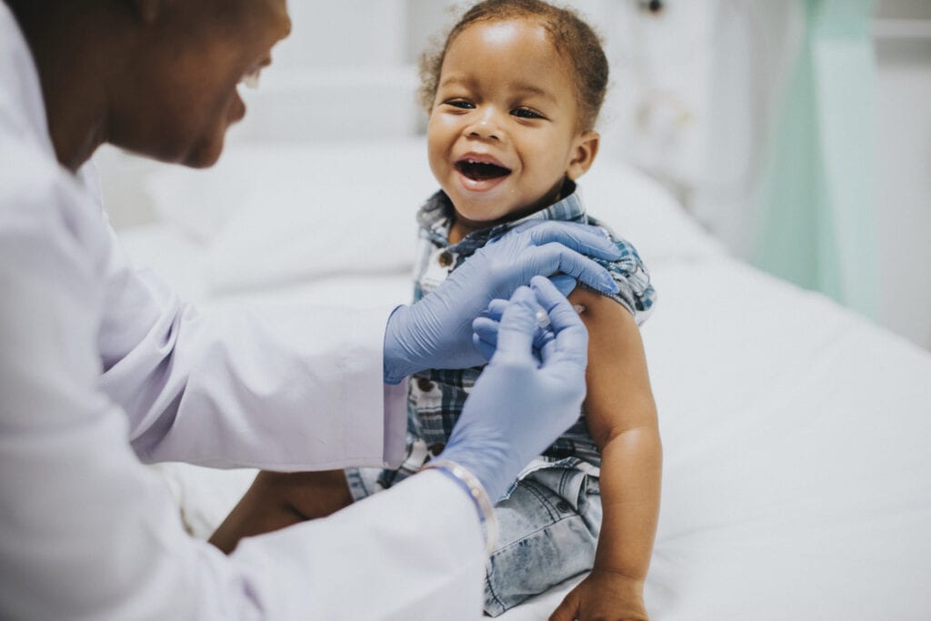 A imagem mostra a vacina bcg sendo aplicada no braço de uma criança.