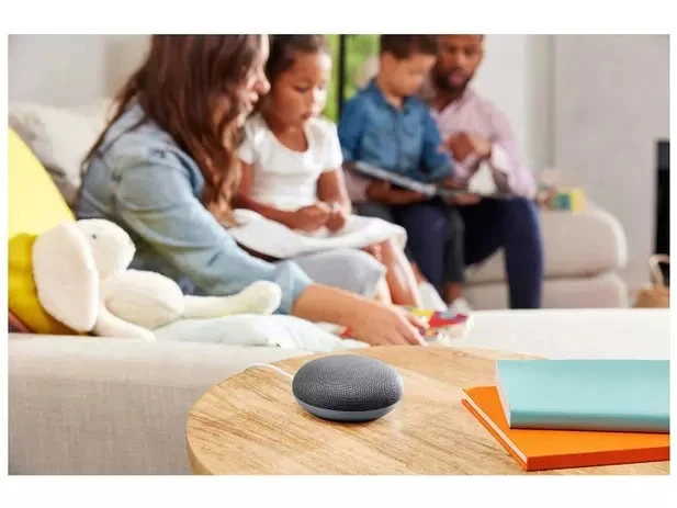 Review: google nest mini compensa pelo ótimo preço de entrada Nest mini no meio de uma sala com uma família