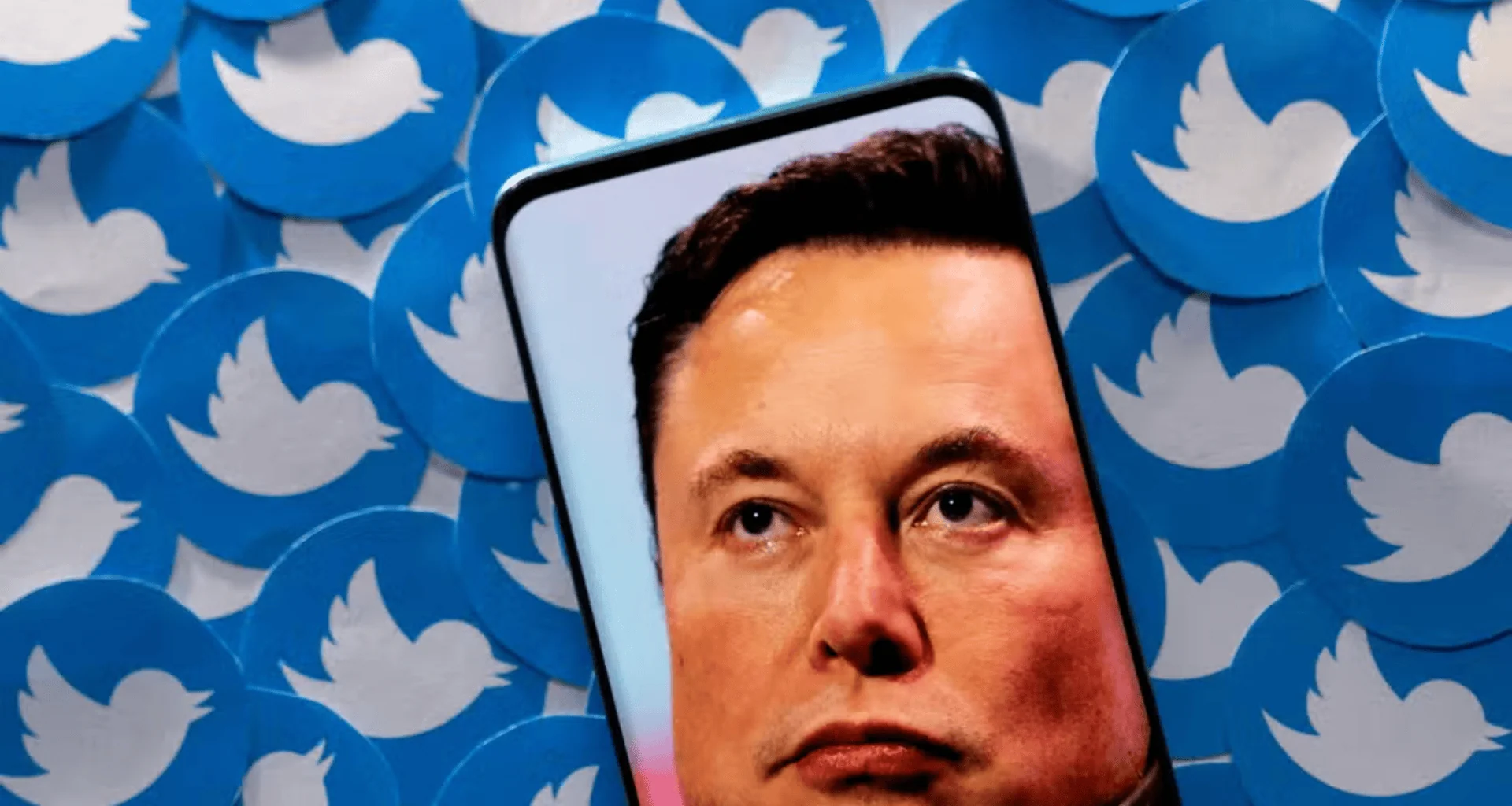 Imagem de um smartphone exibindo elon musk em frente a círculos com o logo do twitter.