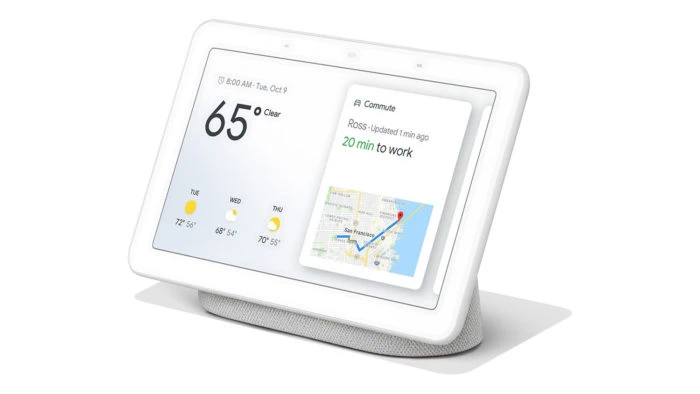 Qual o custo de uma casa conectada do google home? Nest hub para a sua casa conectada com borda e tela branca, na esquerda tem indicação do clima com sessenta e cinco fahrenteit, embaixo mostra um dia ensolarado, um dia nublado e um dia com sol aparecendo pela metade. No lado, mostra a indicação de tempo de vinte minutos para o trabalho e embaixo um mapa indicando o trajeto realizado.