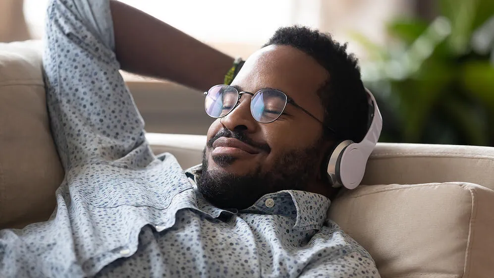 Spotify x apple music x youtube music: qual o melhor serviço de música? Homem ouvindo música após escolher melhor serviço de streaming de música para seu dia a dia