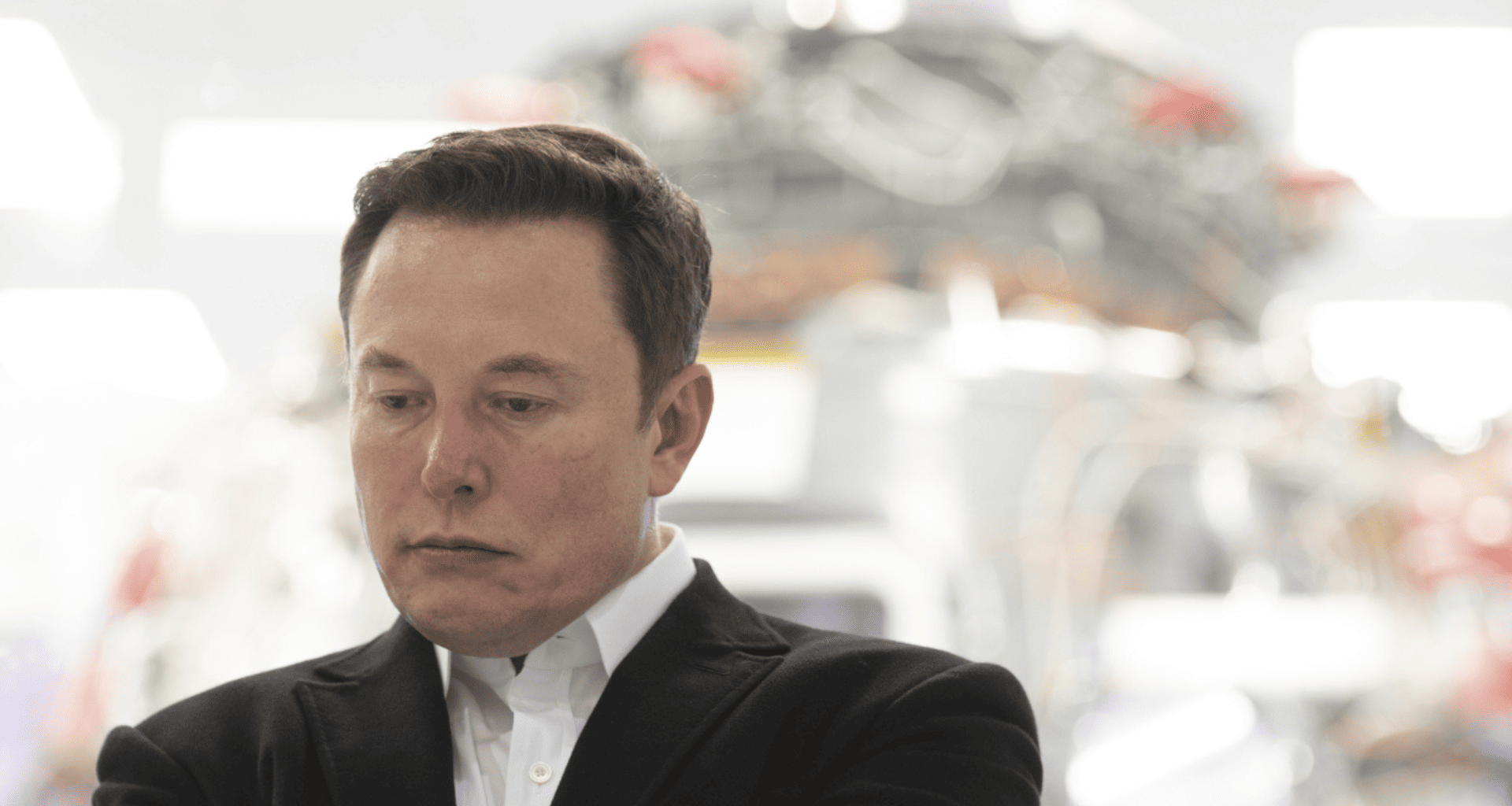 Imagem de elon musk pensativo, referência às perdas financeiras no mercado de tecnologia.