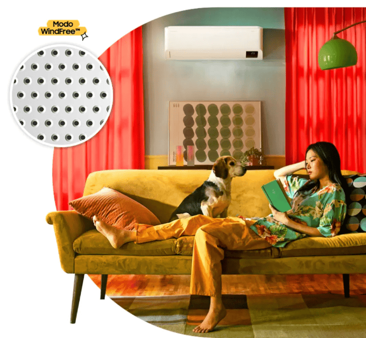 Imagem de mulher relaxando no sofá com um cachorro em ambiente com ar-condicionado.
