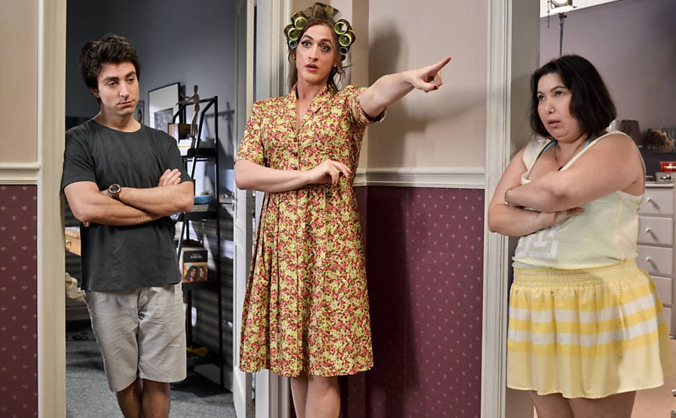 Imagem de três pessoas conversando em casa, uma delas com rolos de cabelo.