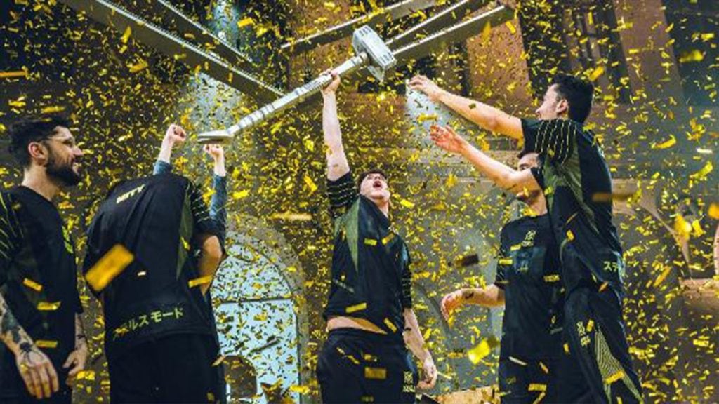 Campeões do six invitational celebrando com troféu e confete dourado.