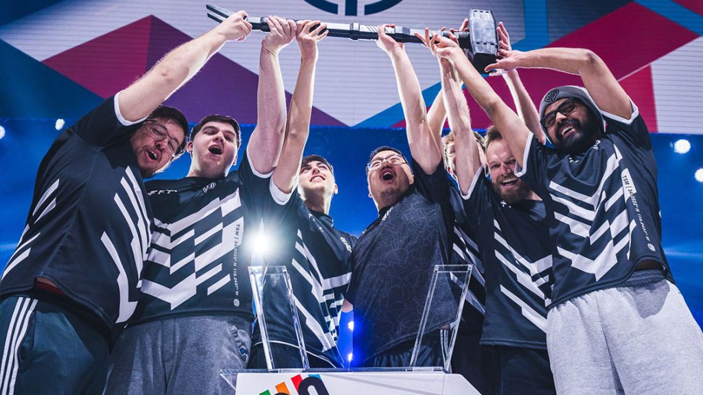 Jogadores comemorando vitória do six invitational com troféus no palco.