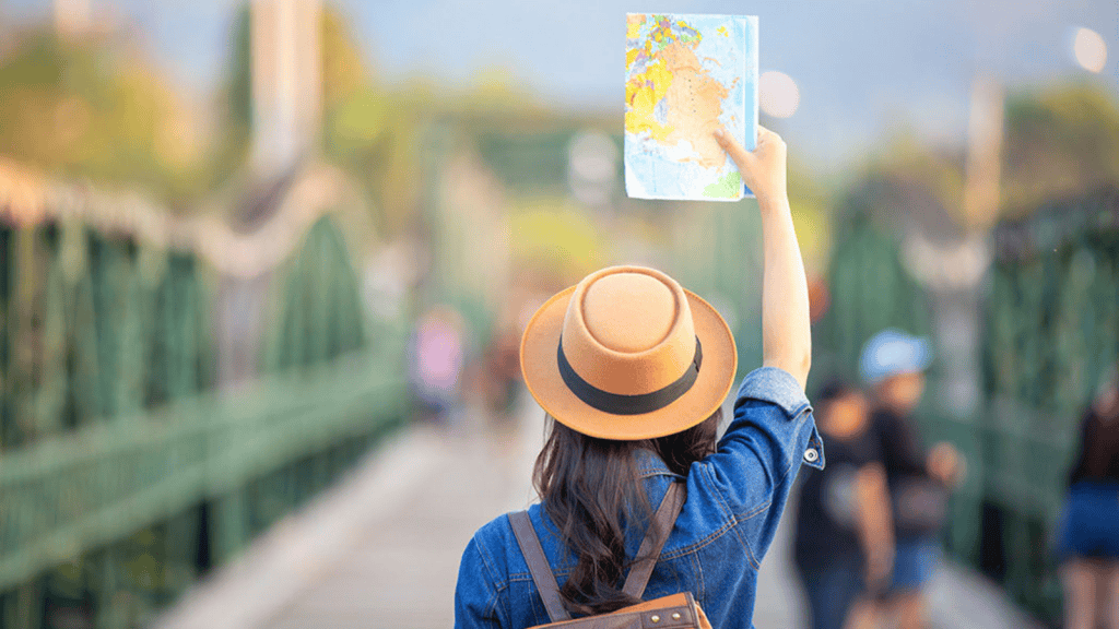 Mapa en mano, mujer explorando nuevas regiones al aire libre utilizando tecnología de navegación.