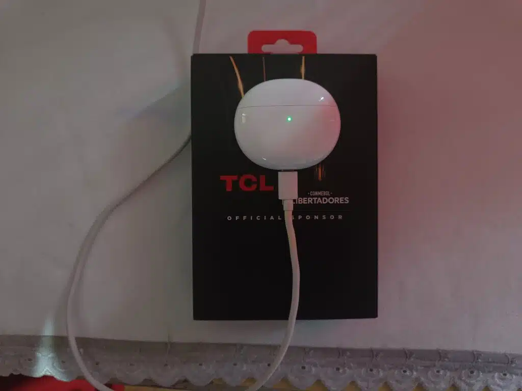 Review: fone de ouvido bluetooth tcl moveaudio s600 Moveaudio s600 da tcl recarregando sobre uma mesa