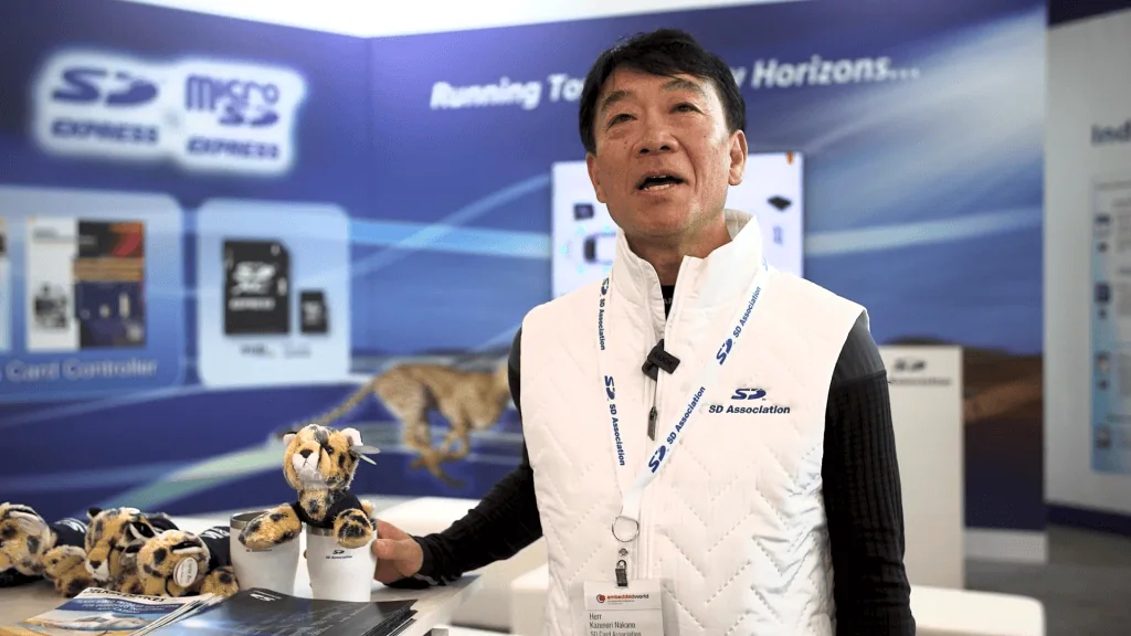 Como saber se seu cartão de memória é falso Cartão de memória t alt | kazunori nakano, visto em primeiro plano, usando uma jaqueta de cor branca, à direita de um bicho de pelúcia.