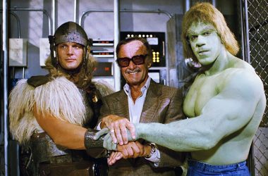Homem com fantasia de guerreiro, homem com blazer e óculos escuros, hulk com corpo verde e músculos, todos de mãos dadas.