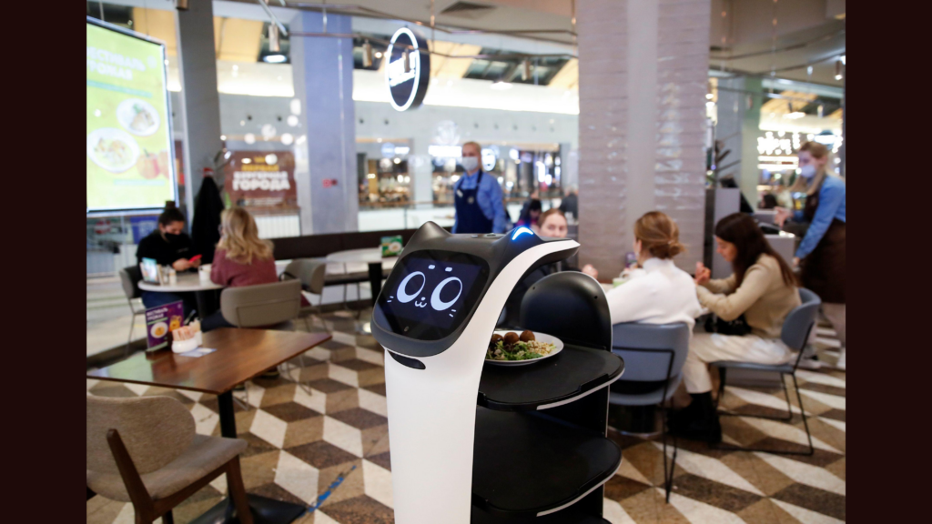 O garçom robô fofo da pudutech é um robô projetado para trabalhar em restaurantes e ajudar a entregar comida e bebida aos clientes. Além disso, a empresa também apresenta o assistente holabot, cujas tarefas incluem o transporte de louça suja para a cozinha.