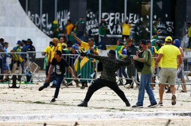 Atrapalhar eleições no brasil t alt destaq vidro quebrado em primeiro plano, com logo pessoas espalhadas em toda a imagem, destruindo estruturas do local