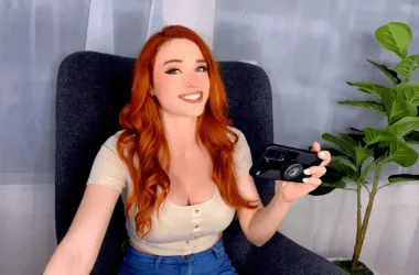 1. Mulher com cabelo ruivo segurando smartphone em ambiente moderno com planta.