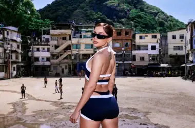 1. Mulher com biquíni estiloso na praia, condomínio de favelas ao fundo, moda praia e lifestyle.