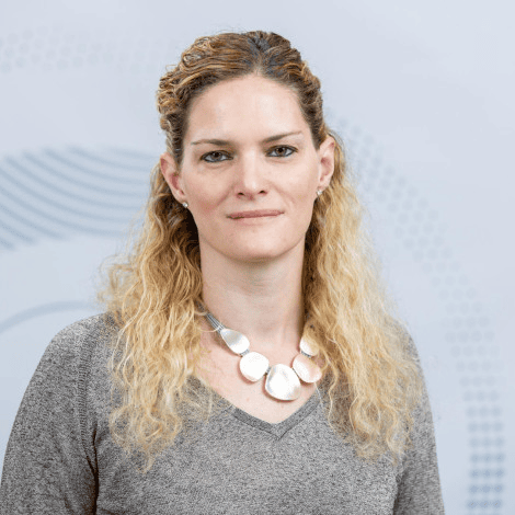 Embrião humano sintético é criado em laboratório Organismos sintéticos t alt 3a pesquisadora vista em fundo cinza, usando uma roupa da mesma cor, em um tom mais escuro