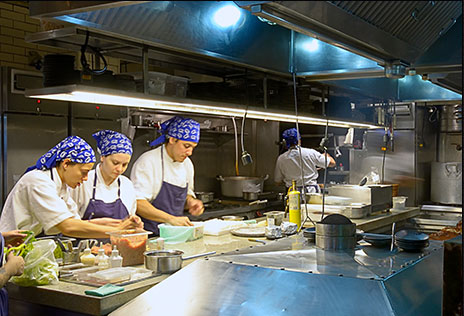 Experiência gastronômica t alt pessoas cozinhando em restaurante, usando toucas em cor azul