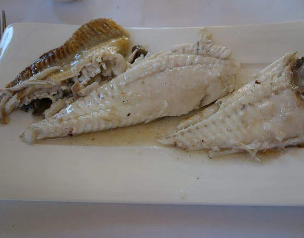 Experiência gastronômica t alt 22 peixes em cor branca, dispostos em prato da mesma cor, um tanto mais claro; as peças estão em diagonal, lado a lado, vistos de frente