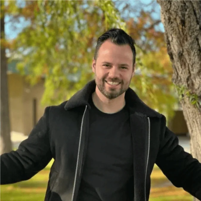 Programcı yapay zekayı kullanarak kız arkadaşını yeniden yaratıyor (ai) Kız arkadaşından ilham alarak tarzını yaratan Enias cailliau, açık hava ortamında siyah kıyafetler giyerek, arka planda ağaçlarla poz verdi.