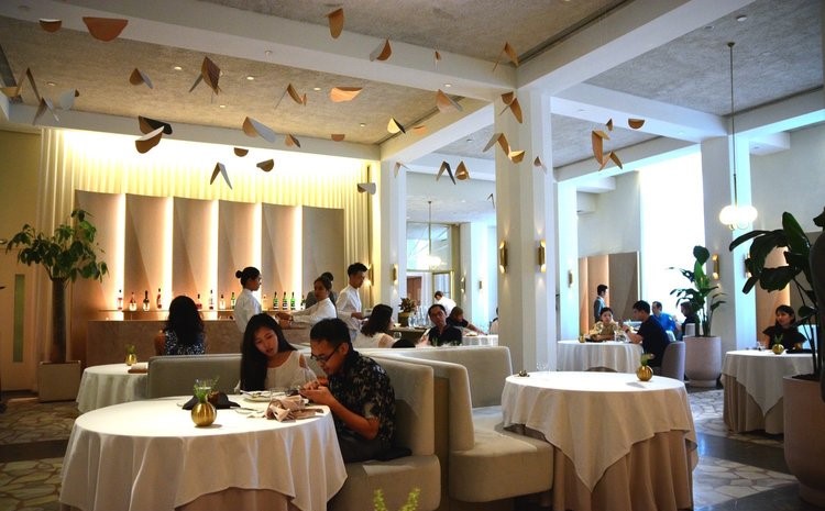 Menu do restaurante 14 t alt sala com mesas de pano em cor branca, iluminadas por luz clara no interior