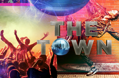 Começo de show com público animado e artista dançando em fundo colorido e vibrante.