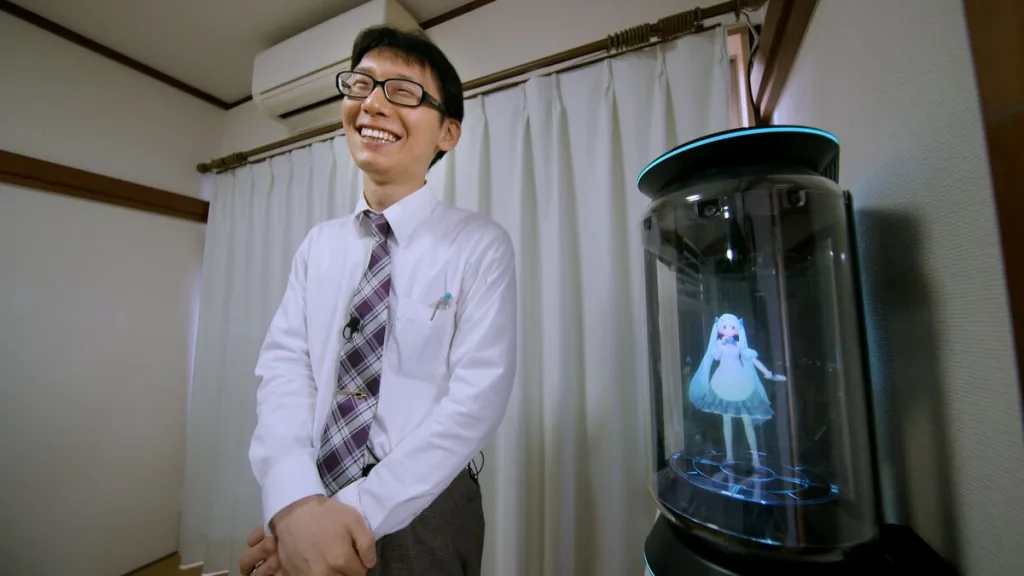 Akihiro kondo ao lado de um holograma de sua companheira hatsune miku