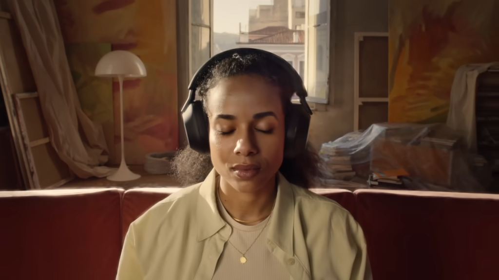 Mulher usando o headphone sony xm5 preto de olhos fechados