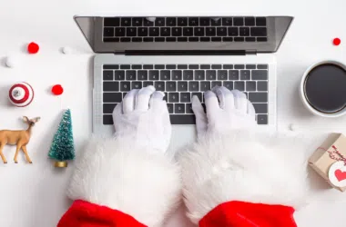 Teclado de notebook com temas natalinos, decoração de natal e presentes, cenário de festa e tecnologia.