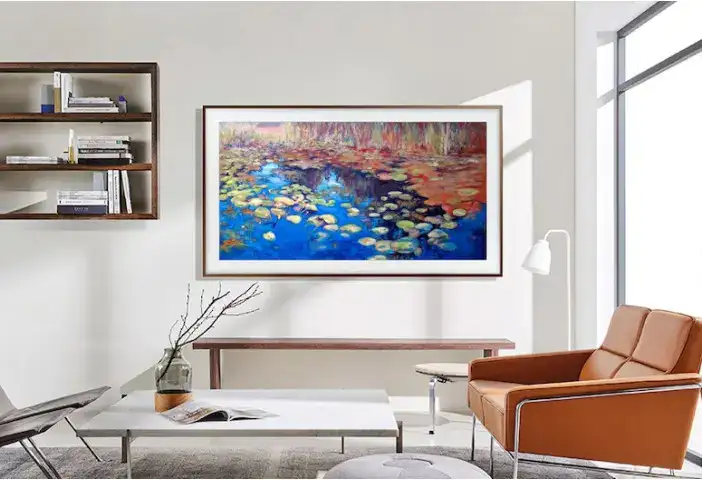 Conjunto de sala moderna com quadro de água, sofá de couro e estante com livros clean.