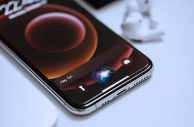 Fone iphone 12 com tela vibrante e siri ativada em ambiente de escritório moderno.
