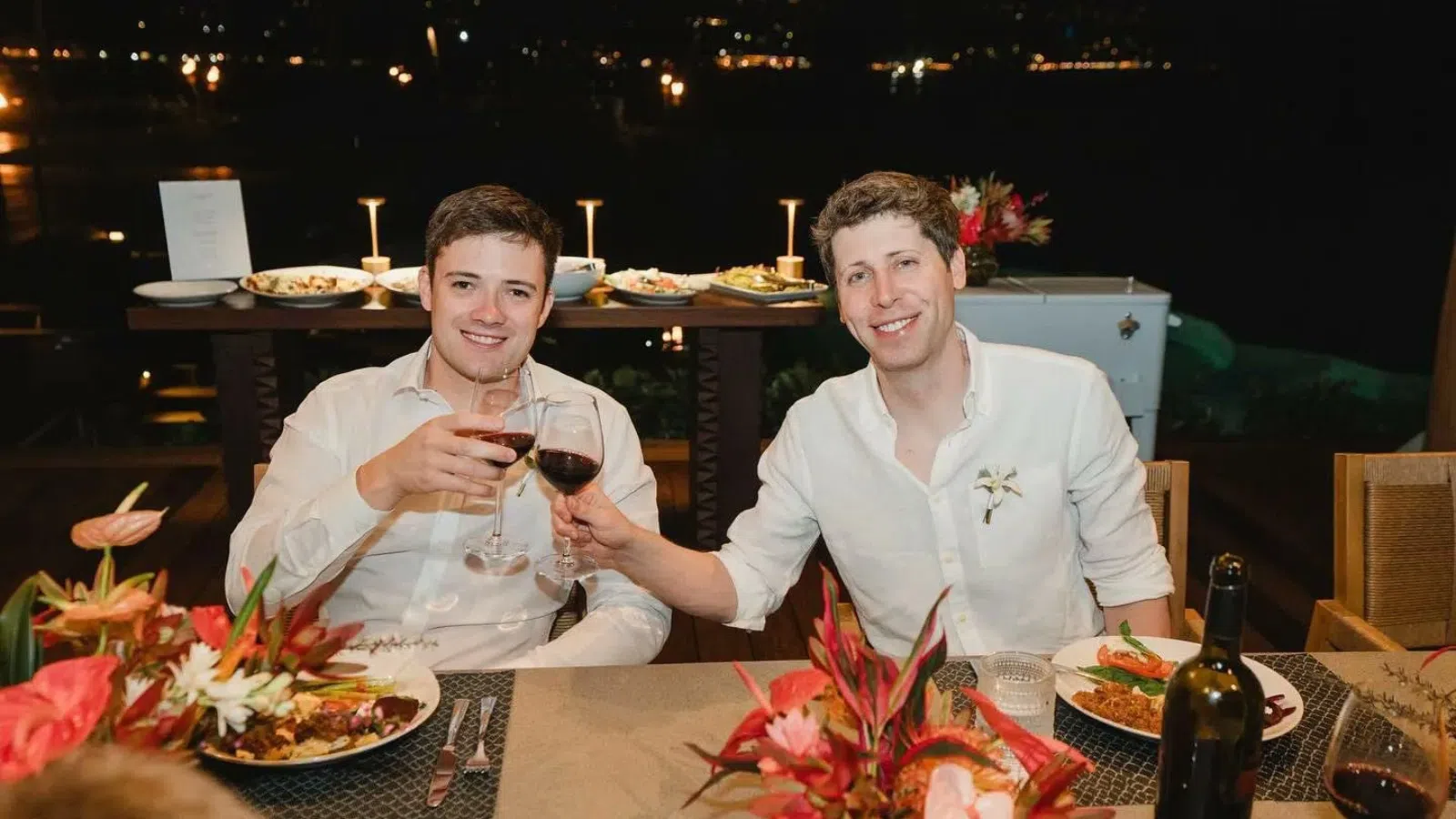 Amigos brindando com vinho em jantar ao ar livre à noite, celebração entre amigos.