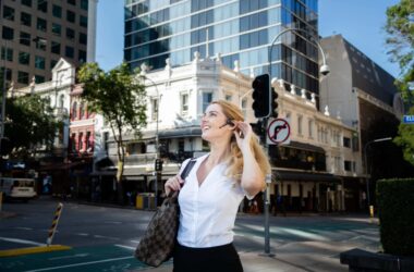 1. Mulher usando fone de ouvido bluetooth no centro de uma cidade moderna.